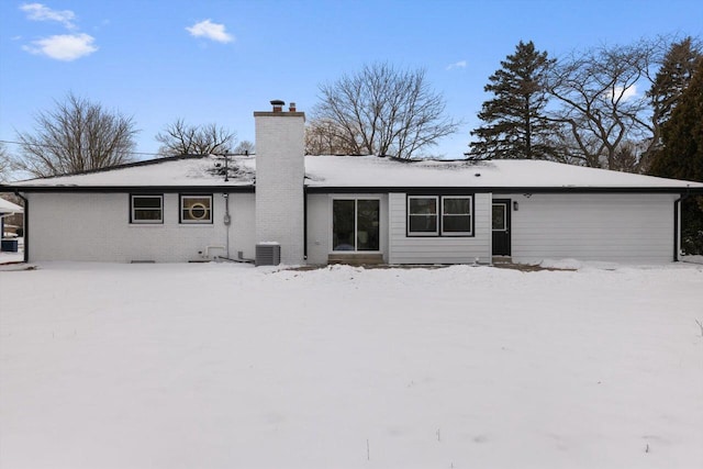 snow covered back of property with central air condition unit