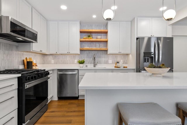 kitchen with white cabinetry, sink, pendant lighting, and appliances with stainless steel finishes