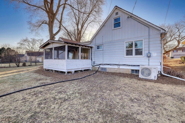 back of property with ac unit and a sunroom