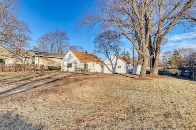 rear view of house with fence and a yard