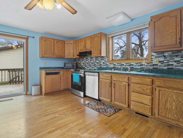 132 E Carroll St, Portage, WI 53901 - kitchen with stainless steel appliances, under cabinet range hood, backsplash, and light wood-type flooring