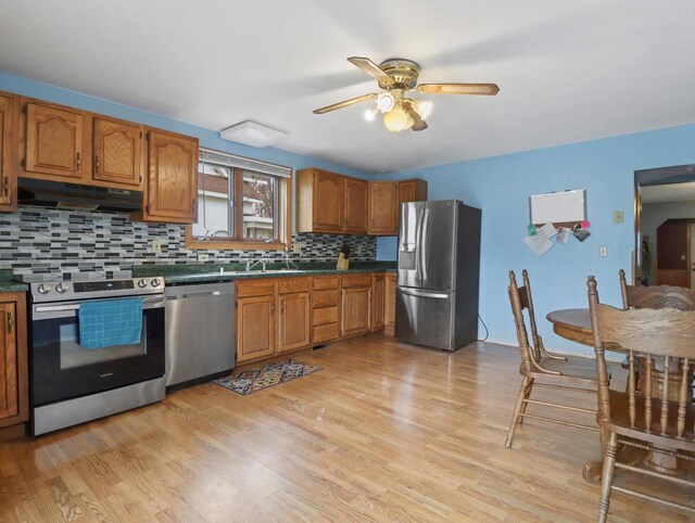 132 E Carroll St, Portage, WI 53901 - kitchen featuring appliances with stainless steel finishes, under cabinet range hood, a ceiling fan, and brown cabinetry