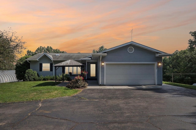 ranch-style house featuring a garage, a gazebo, and a lawn