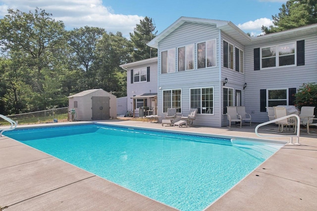 view of swimming pool with a storage shed and a patio area