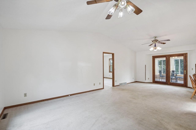 carpeted spare room featuring french doors, ceiling fan, and vaulted ceiling