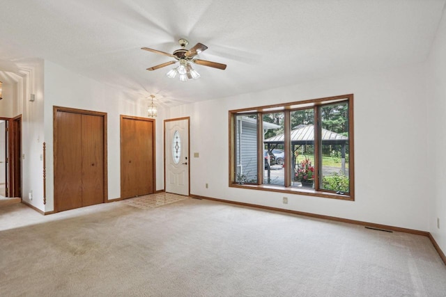 carpeted spare room with a textured ceiling and ceiling fan