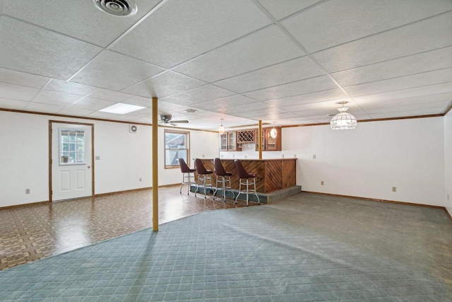 basement with crown molding, bar, and plenty of natural light