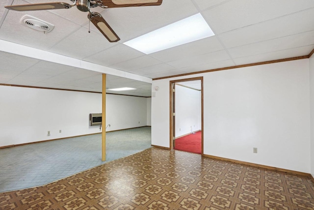 basement with heating unit, crown molding, a paneled ceiling, and ceiling fan