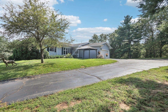 view of front of home featuring a garage, a front yard, and a gazebo