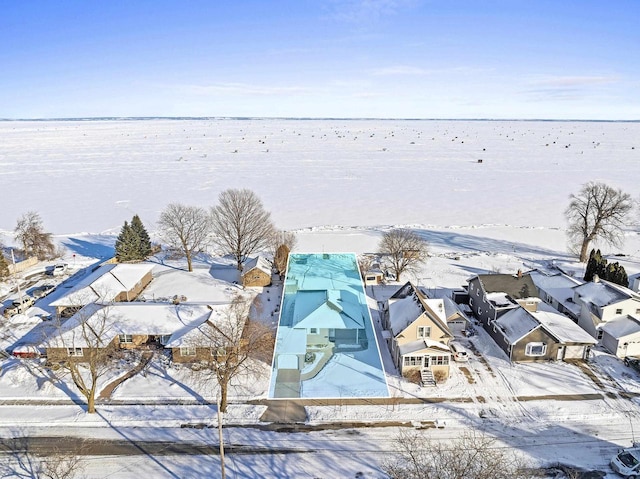 snowy aerial view featuring a water view