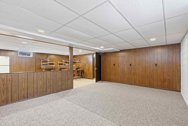 90 Lake St, Oshkosh, WI 54901 - interior space featuring wooden walls, carpet flooring, freestanding refrigerator, a drop ceiling, and bar area
