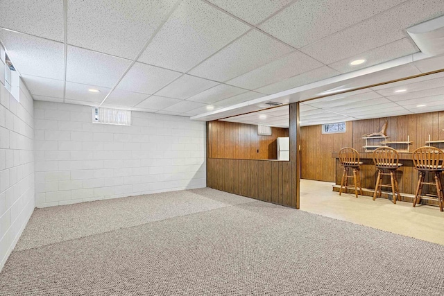 90 Lake St, Oshkosh, WI 54901 - below grade area with a paneled ceiling, concrete block wall, carpet floors, a bar, and wooden walls