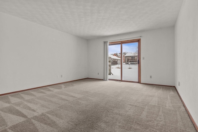 carpeted empty room featuring a textured ceiling