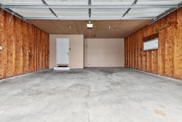 garage featuring a garage door opener and wood walls