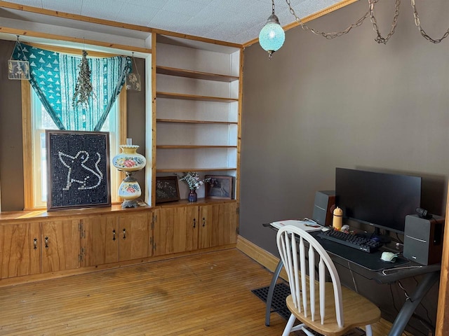 home office with a notable chandelier, light wood finished floors, and baseboards