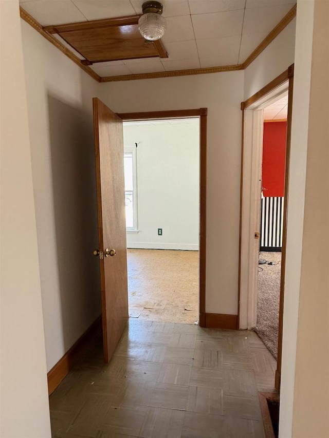 hallway with baseboards and crown molding