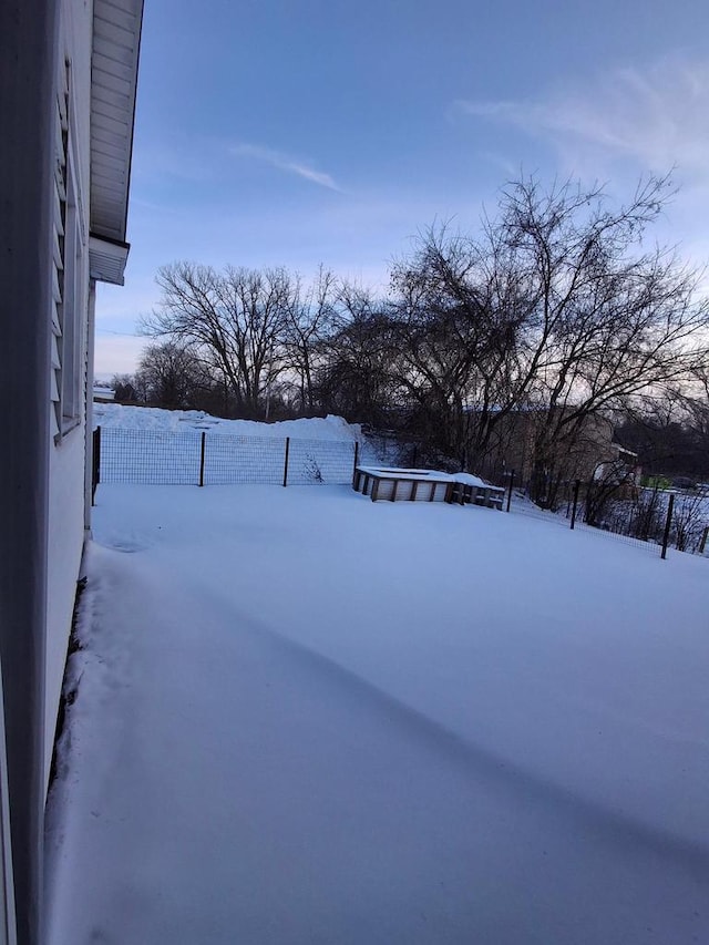 yard layered in snow featuring fence