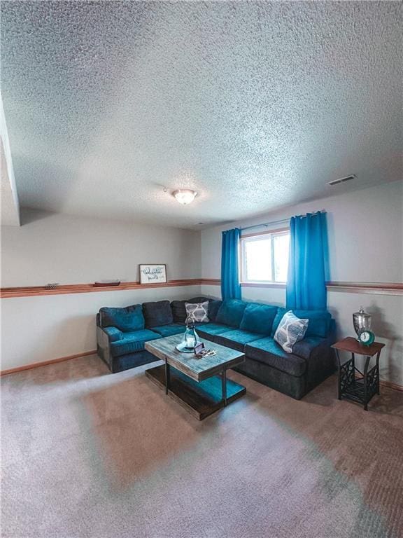 living room with a textured ceiling, carpet floors, visible vents, and baseboards