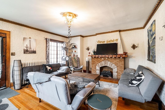 living room featuring hardwood / wood-style flooring, ornamental molding, a brick fireplace, and radiator heating unit