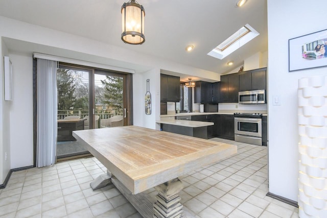 kitchen with a skylight, appliances with stainless steel finishes, light countertops, and light tile patterned flooring