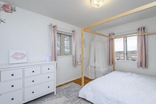 bedroom featuring multiple windows and wood finished floors