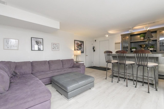 living area with track lighting and wood finished floors