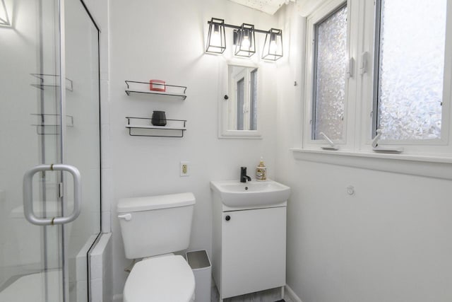 bathroom featuring a stall shower, vanity, and toilet