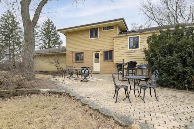 back of house with a patio area and brick siding