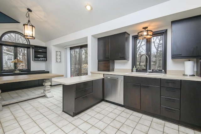 kitchen with a peninsula, a sink, vaulted ceiling, light countertops, and dishwasher