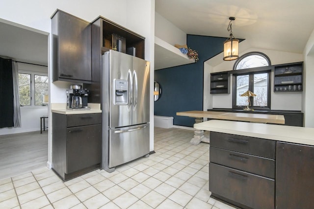 kitchen featuring light tile patterned floors, vaulted ceiling, light countertops, and stainless steel fridge with ice dispenser