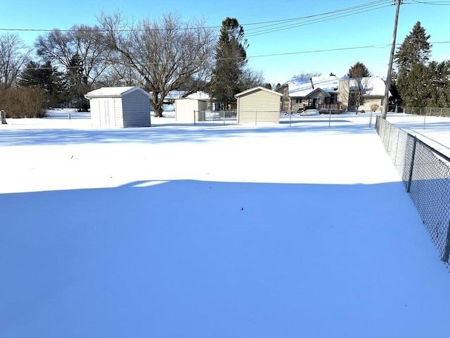 yard covered in snow featuring a storage shed