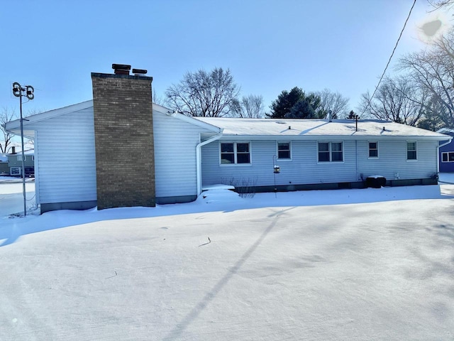 view of snow covered rear of property