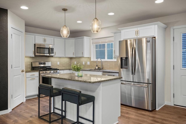 kitchen featuring white cabinets, appliances with stainless steel finishes, dark wood-style flooring, and a sink