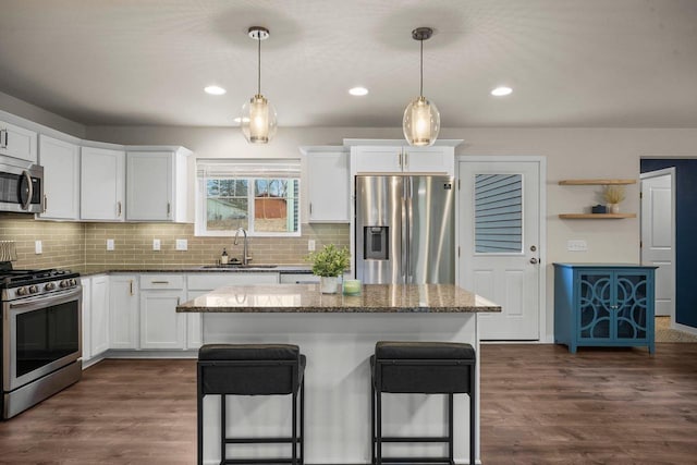 kitchen featuring stainless steel appliances, dark wood-type flooring, a sink, and white cabinets