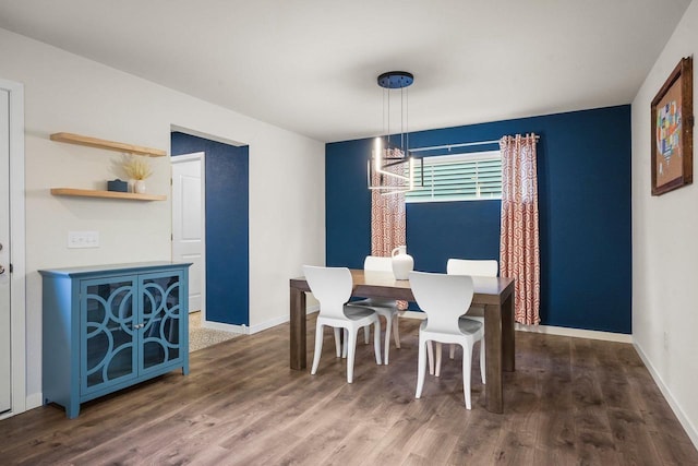 dining space with a notable chandelier, wood finished floors, and baseboards