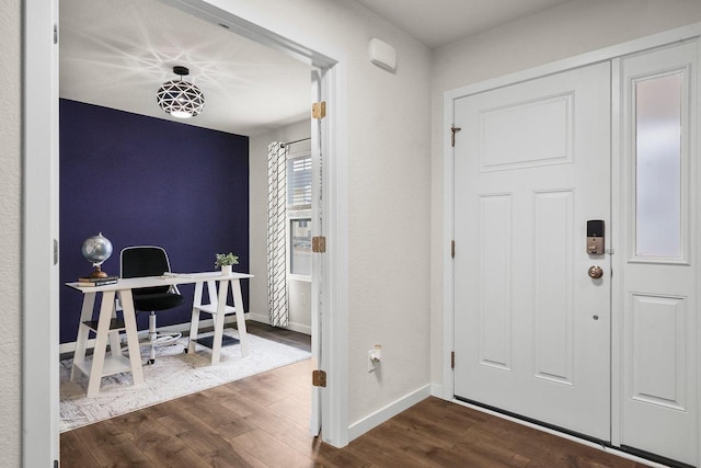 foyer entrance with dark wood-style floors and baseboards