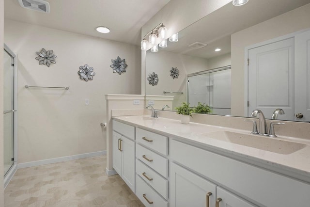 bathroom with a stall shower, a sink, visible vents, and baseboards