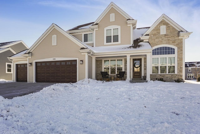 traditional-style house featuring a garage, stone siding, a porch, and driveway