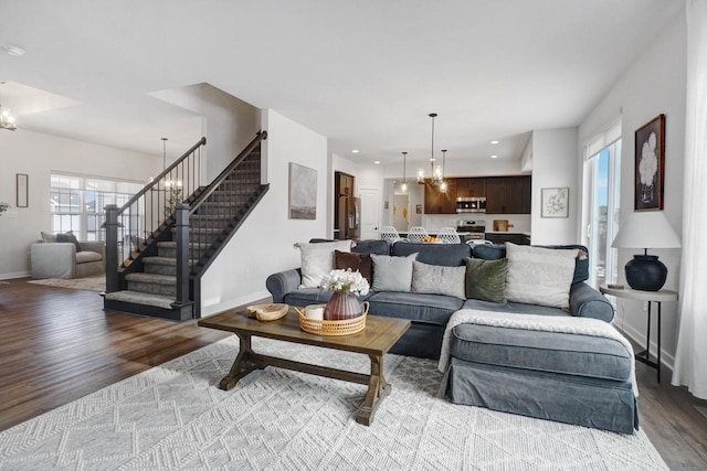 living room with a chandelier, recessed lighting, baseboards, stairway, and light wood finished floors