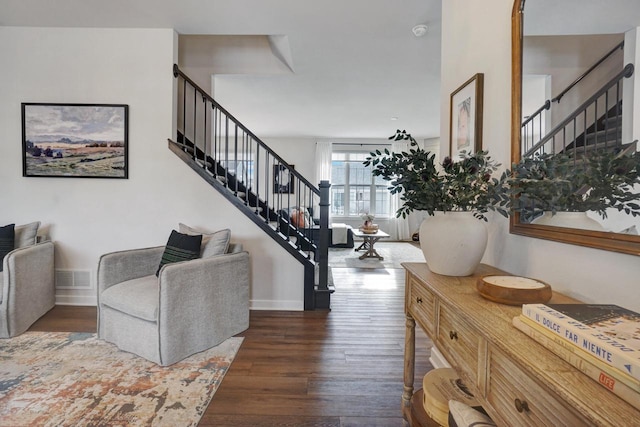 interior space featuring dark wood-type flooring, visible vents, stairway, and baseboards