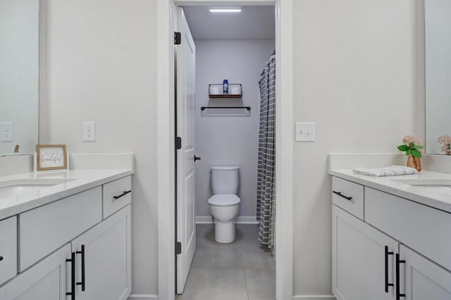 bathroom with toilet, a sink, two vanities, and tile patterned floors