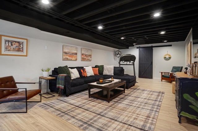 living area featuring light wood-type flooring and a barn door