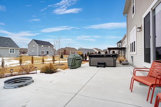 snow covered patio featuring a pergola, a residential view, and a hot tub