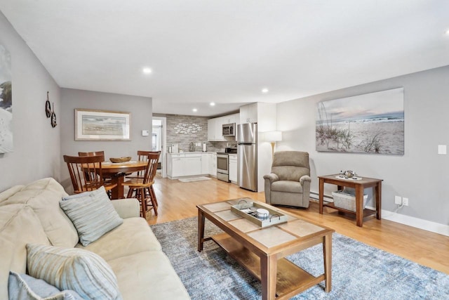 living room featuring light wood-type flooring and a baseboard heating unit