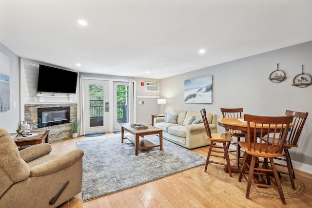 living room featuring light hardwood / wood-style flooring and a stone fireplace