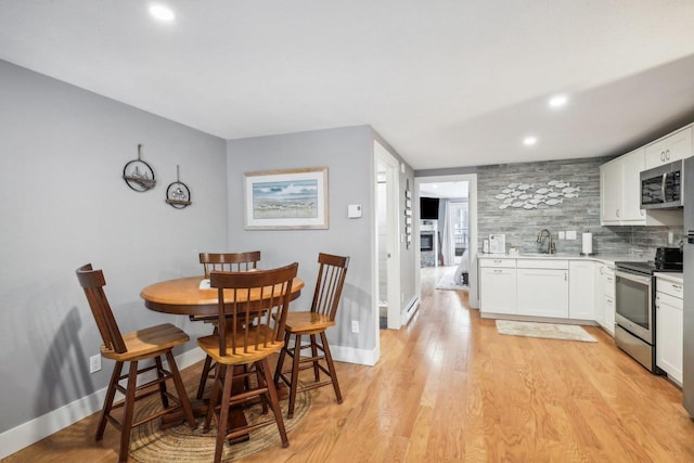 dining area with sink and light hardwood / wood-style floors