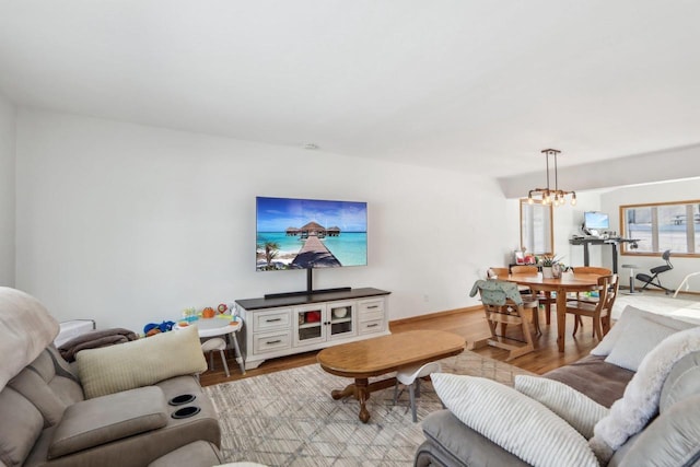 living room with an inviting chandelier and light hardwood / wood-style flooring