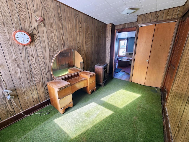 unfurnished bedroom featuring wooden walls and carpet flooring