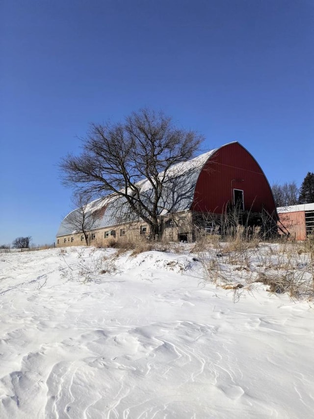 yard layered in snow featuring an outbuilding