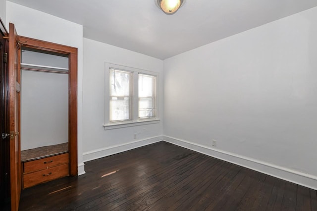 unfurnished bedroom with dark wood-type flooring